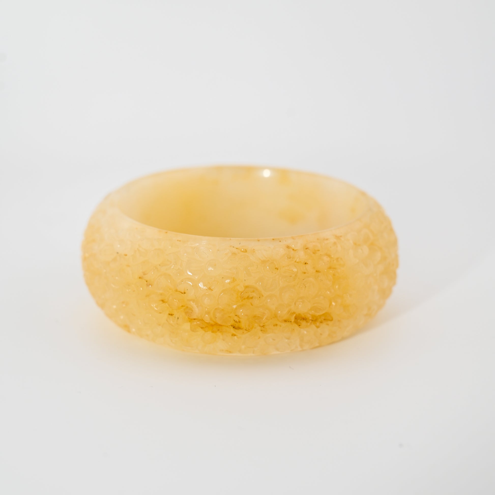 Floral-engraved light honey Burmese jadeite bangle cuff with differing front and back patterns