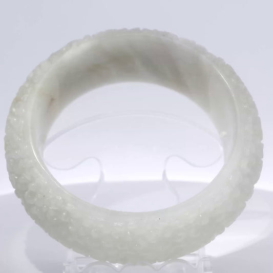 Icy Off-White Carved Jade Bangle, front view on display stand, authentic Type A Burma jadeite, Brother Ryan Shop